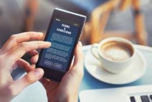 lire sur son smartphone en prenant un cafe